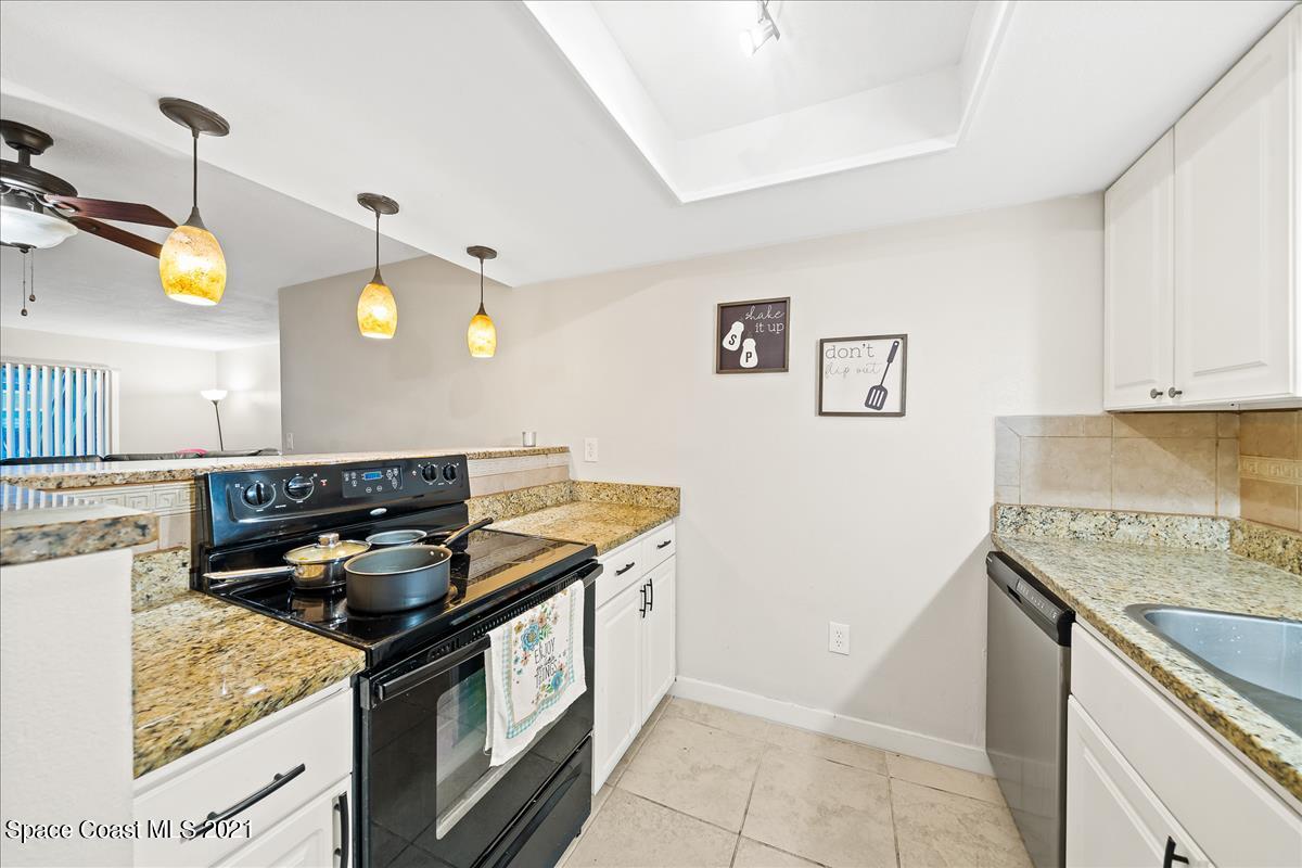 151 Ulster Lane Melbourne, FL 32935 - Photo 6 of 14 a kitchen that has a sink a stove and a table