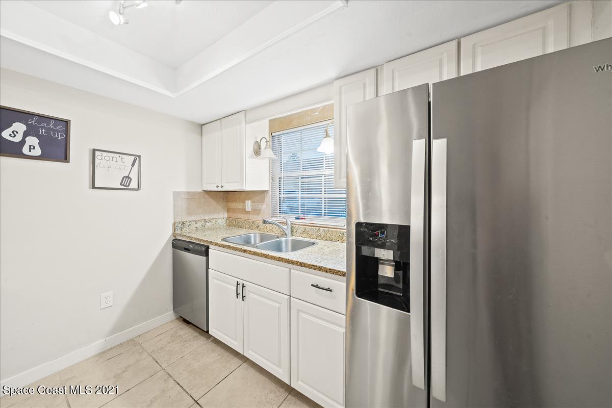 151 Ulster Lane Melbourne, FL 32935 - Photo 7 of 14 a kitchen with stainless steel appliances granite countertop a refrigerator and a stove