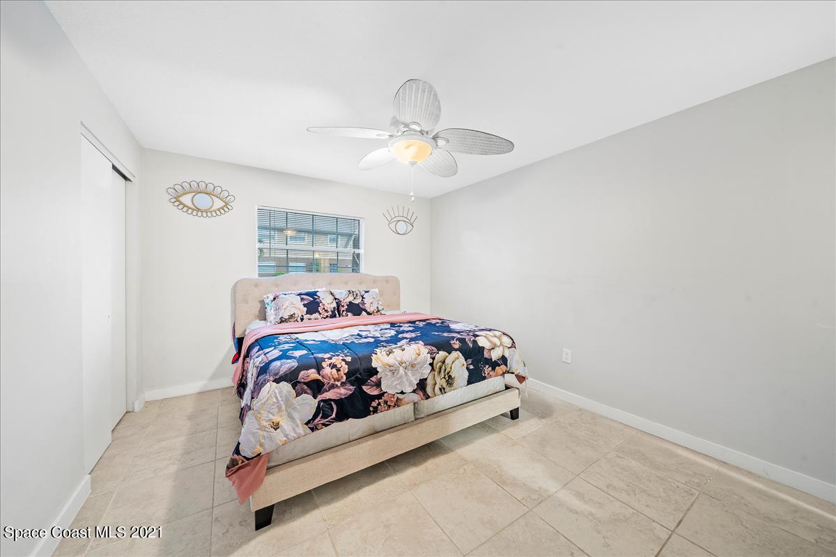 151 Ulster Lane Melbourne, FL 32935 - Photo 9 of 14 a bedroom with a bed and a chandelier