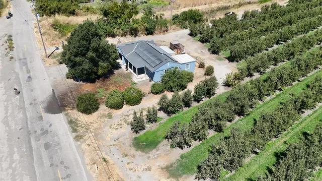 an aerial view of a house with a yard and trees