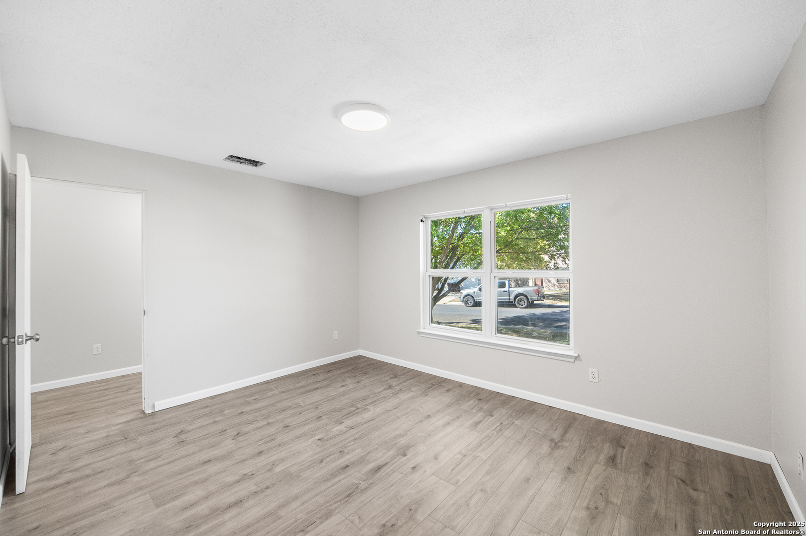 8010 Chestnut Gate Drive Converse, TX 78109 - Photo 19 of 37 an empty room with wooden floor and windows