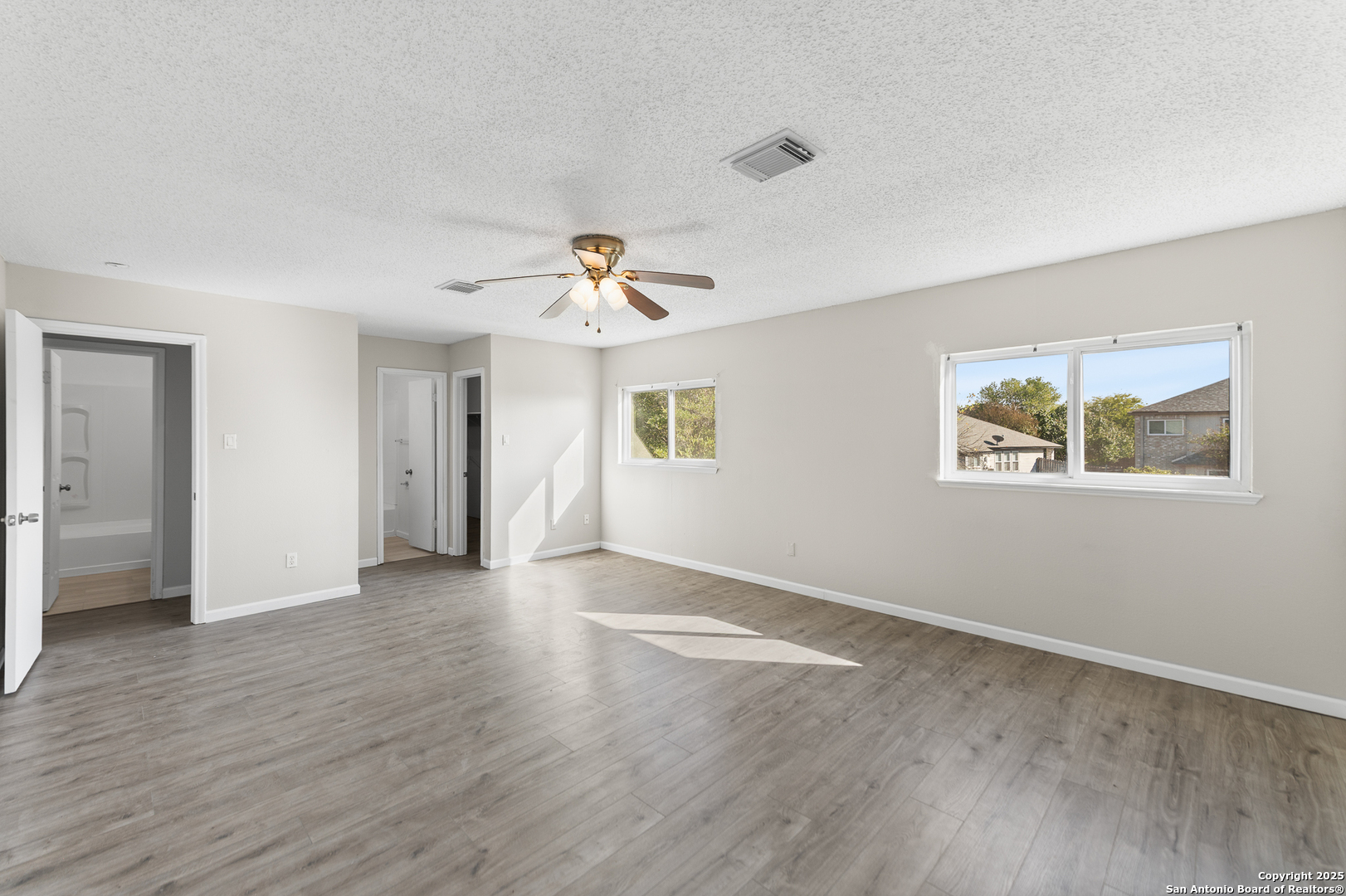 8010 Chestnut Gate Drive Converse, TX 78109 - Photo 22 of 37 a view of an empty room with wooden floor and a window