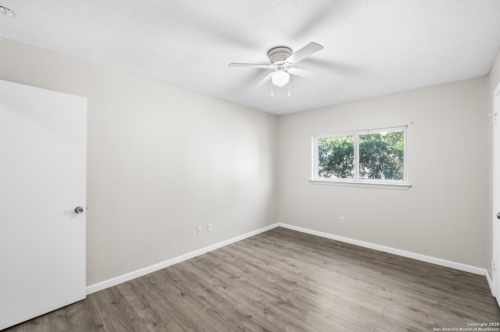 8010 Chestnut Gate Drive Converse, TX 78109 - Photo 29 of 37 an empty room with wooden floor fan and windows