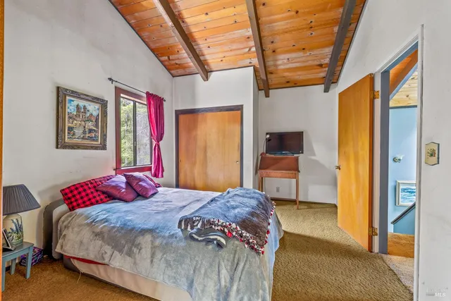 a bedroom with a bed a dresser next to a window