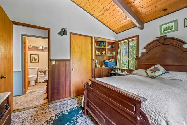 a bedroom with a bed and a dresser next to a window