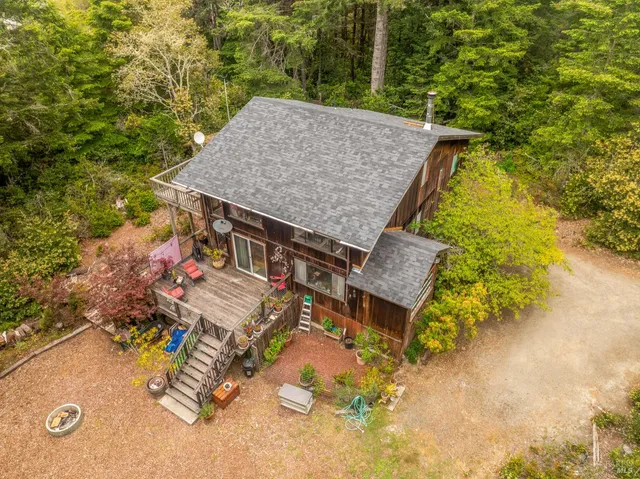 an aerial view of a house with swimming pool and trees