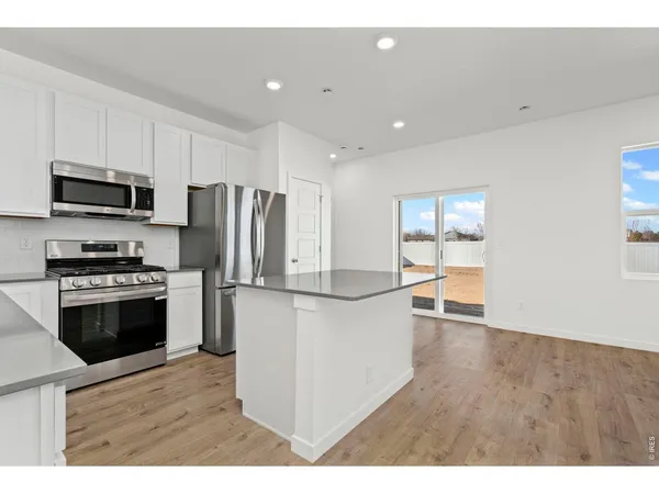 a kitchen with kitchen island a refrigerator sink and microwave
