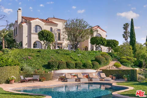 a view of a house with swimming pool and sitting area