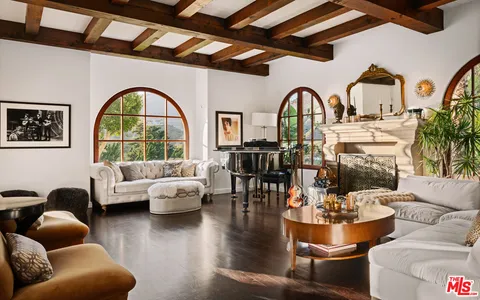 a living room with fireplace furniture and a large window