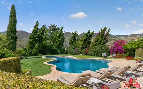 a view of a swimming pool with a yard and a garden
