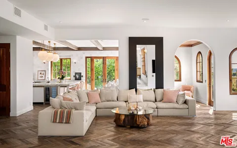 a living room with fireplace furniture and floor to ceiling windows