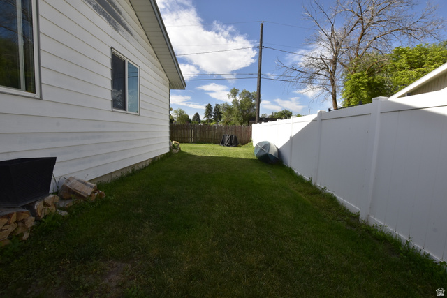 290 West 600 North Logan, UT 84321 - Photo 8 of 45 Expansive grass yard with a white vinyl fence and white siding