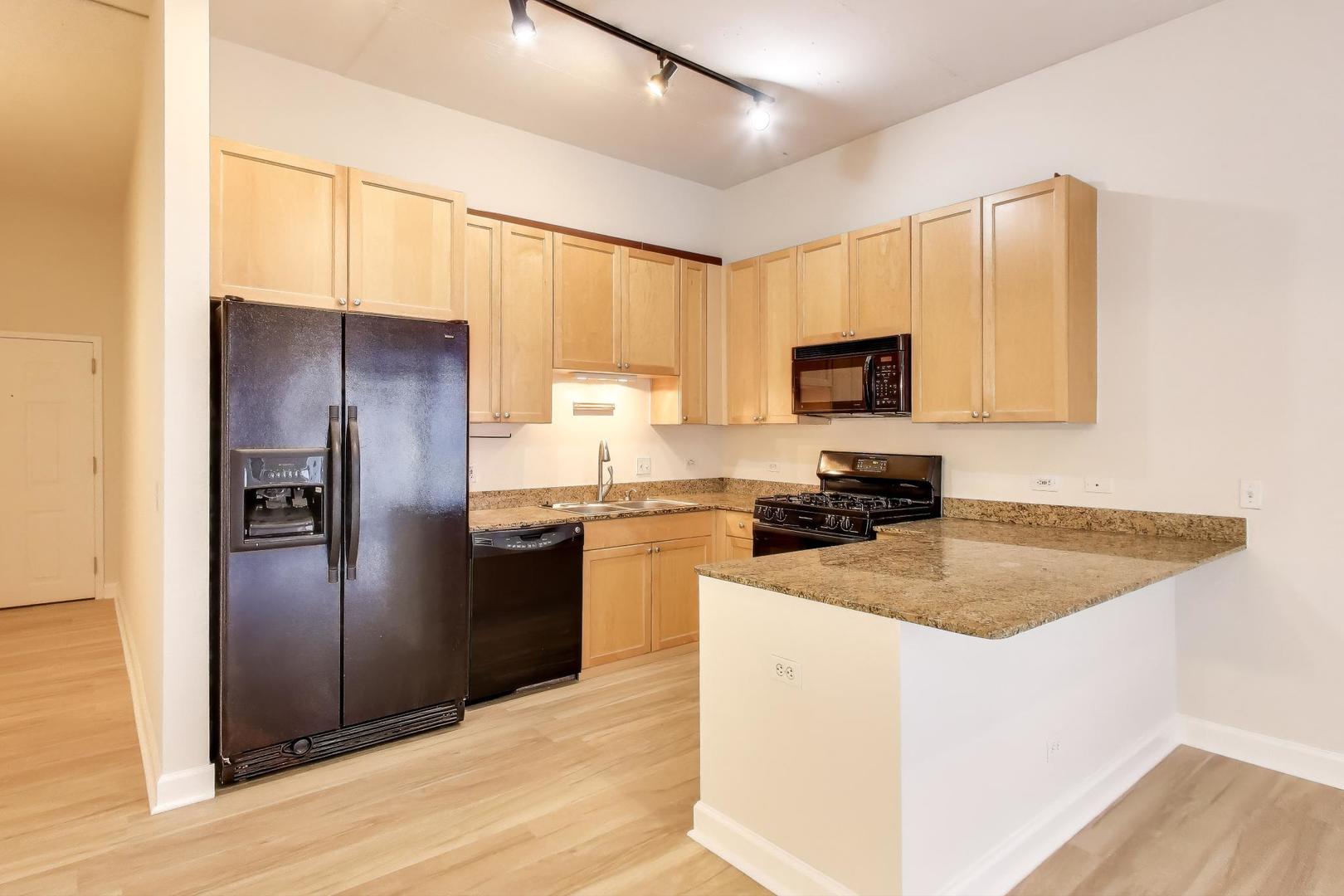 910 West Madison Street, Unit 409 Chicago, IL 60607 - Photo 5 of 14 a kitchen with a refrigerator sink and microwave