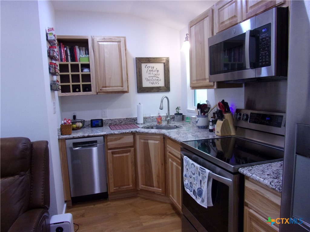 2471 Rolling River View Spring Branch, TX 78070 - Photo 10 of 23 a kitchen with stainless steel appliances granite countertop a sink stove and microwave