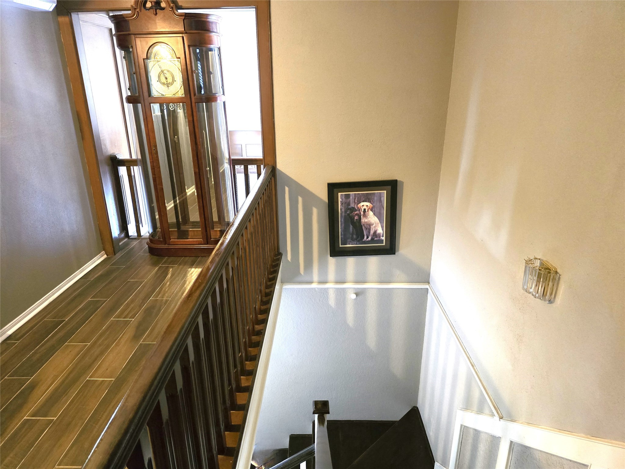 560 Brandon Road Conroe, TX 77302 - Photo 16 of 45 Elegant staircase with rich wood detailing and ample natural light, leading to a cozy upper landing.