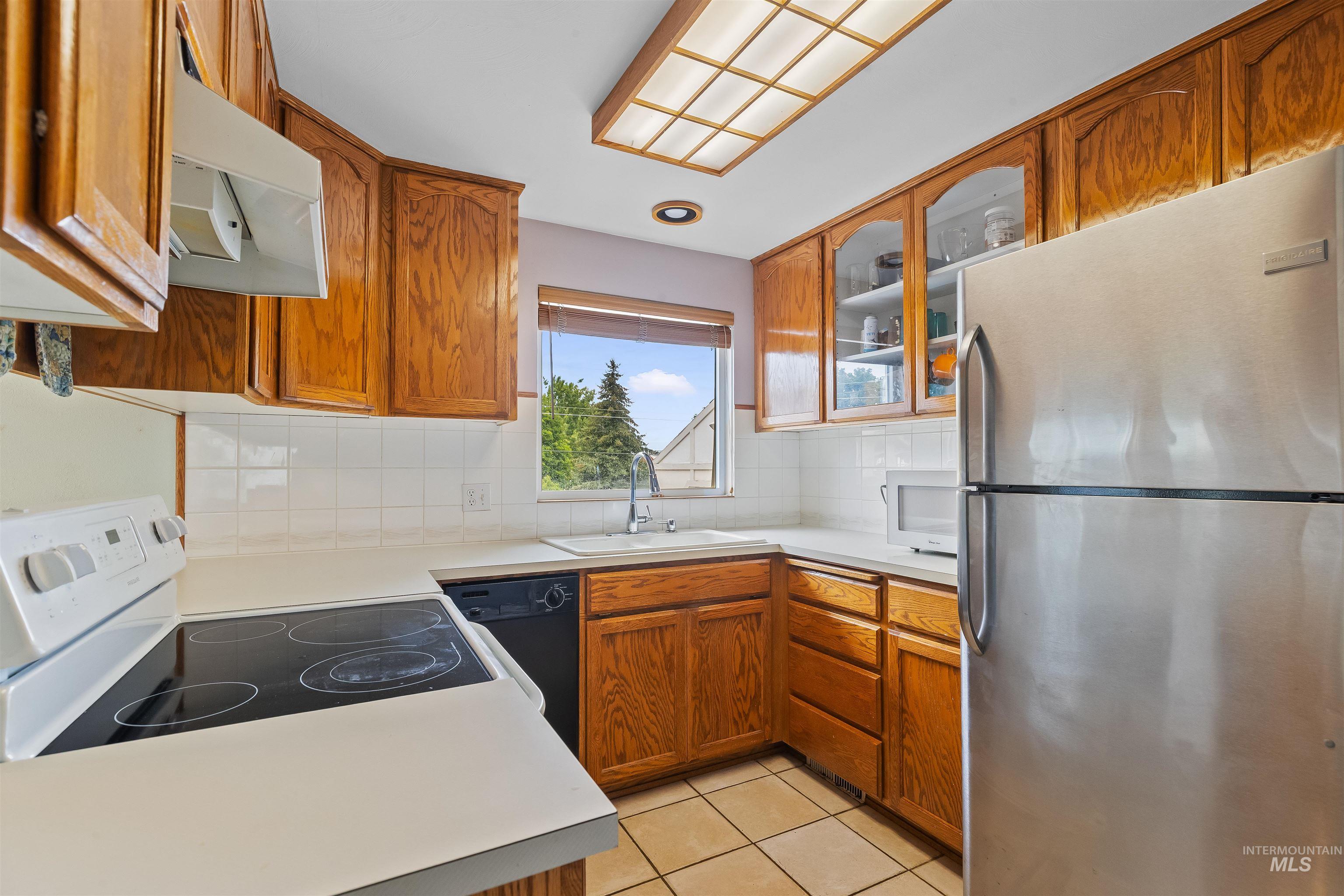 3620 18th Street Lewiston, ID 83501 - Photo 5 of 32 Kitchen featuring wood cabinetry, white tile backsplash, and a window above the sink