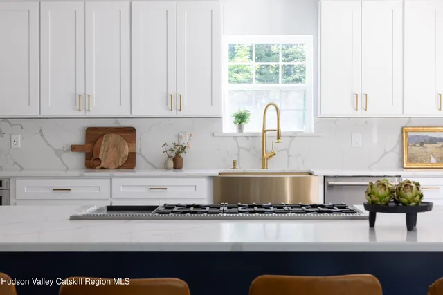 a kitchen with stainless steel appliances granite countertop a stove a sink and a white cabinets