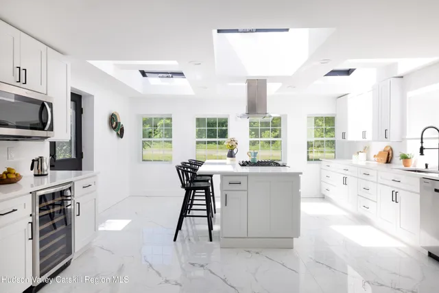 a kitchen with stainless steel appliances kitchen island granite countertop a sink and cabinets