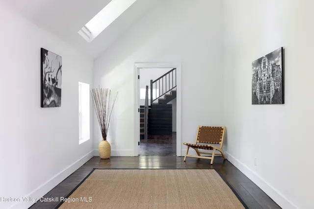 a view of a livingroom with wooden floor and a hallway