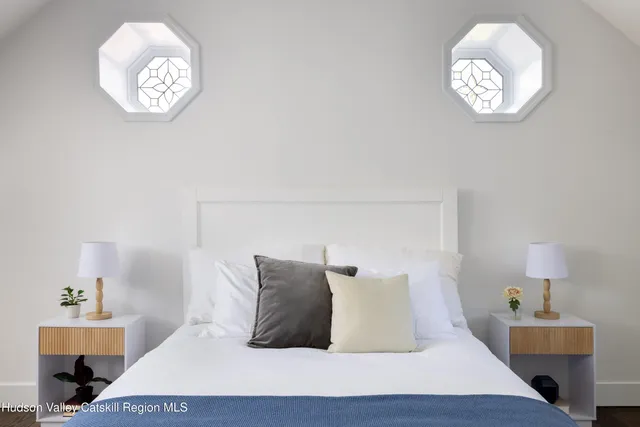 a bed sitting in a bedroom next to a window with a chandelier