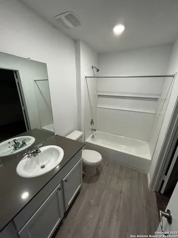 a bathroom with a granite countertop sink toilet a mirror and shower