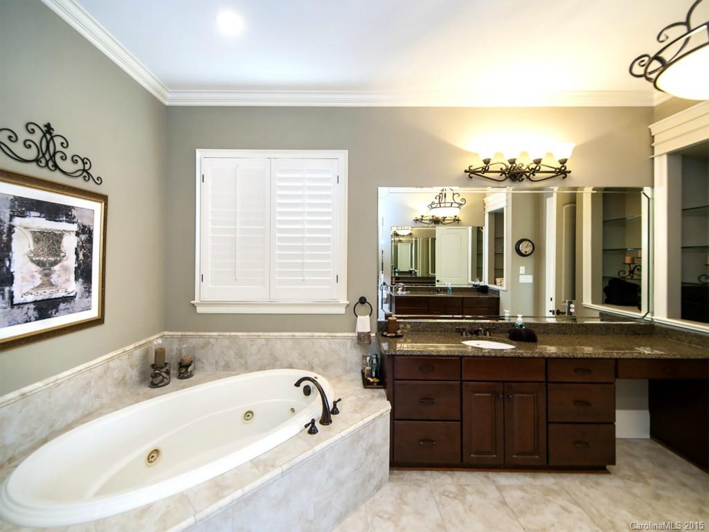 262 Horton Grove Road Fort Mill, SC 29715 - Photo 15 of 24 a bathroom with a tub a double vanity sink and a large mirror