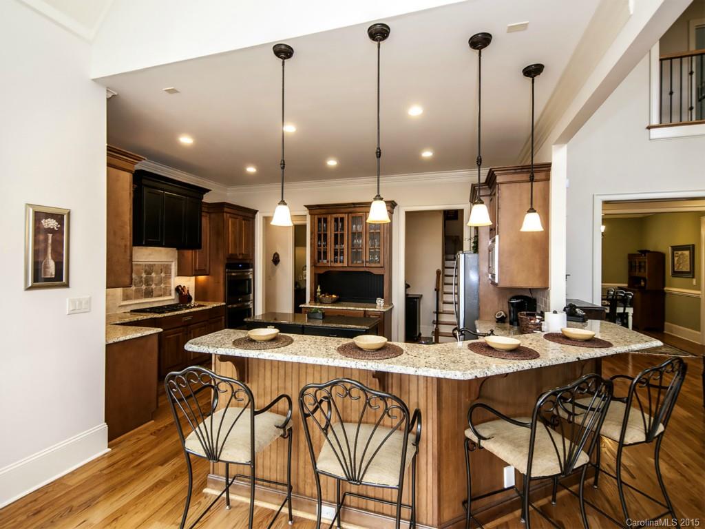 262 Horton Grove Road Fort Mill, SC 29715 - Photo 8 of 24 a kitchen with stainless steel appliances kitchen island granite countertop a dining table chairs sink and white cabinets