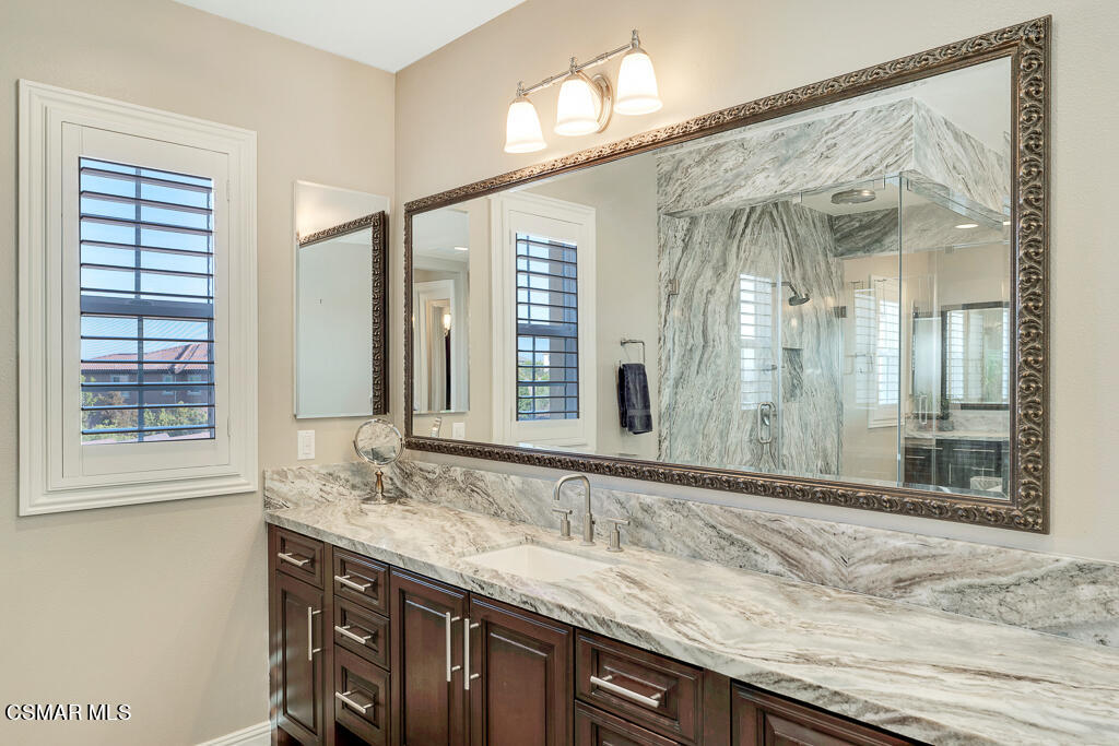7379 Nicklaus Road Moorpark, CA 93021 - Photo 53 of 85 a bathroom with a granite countertop sink and a mirror
