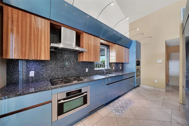a kitchen with stainless steel appliances granite countertop a sink and a refrigerator
