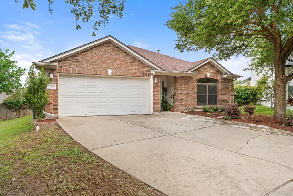 11508 Gossamer Drive Austin, TX 78754 - Photo 13 of 40 Brick residence featuring an attached two-car garage, concrete driveway, and low maintenance landscaping.