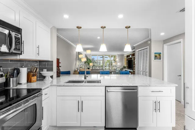 a kitchen with stainless steel appliances granite countertop a sink a stove and a refrigerator