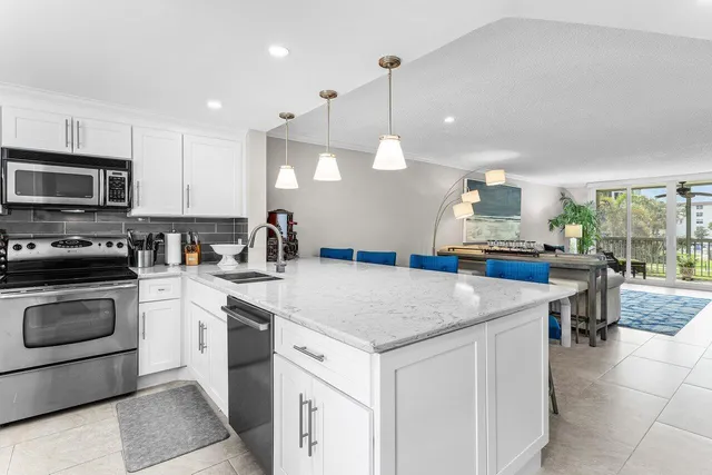 a kitchen with a sink a counter top space appliances and cabinets