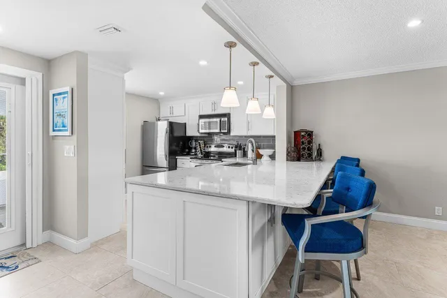 a kitchen with stainless steel appliances a sink a table and chairs