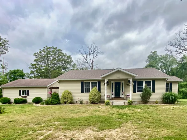 a front view of a house with a garden and trees