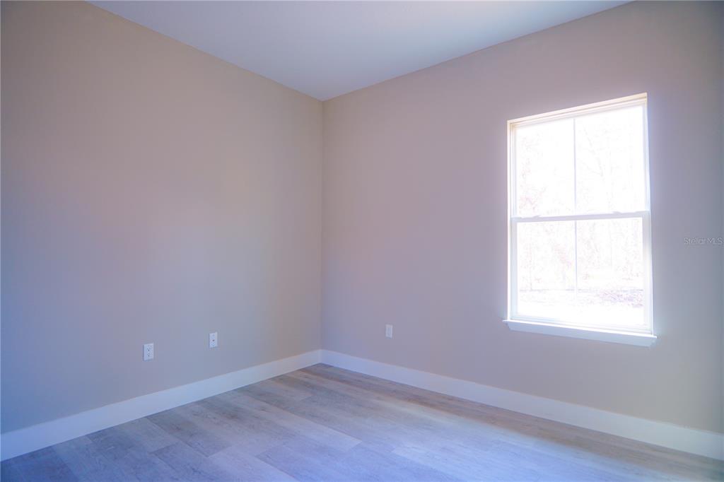 8413 Southwest 131st Lane Ocala, FL 34473 - Photo 15 of 28 an empty room with wooden floor and windows