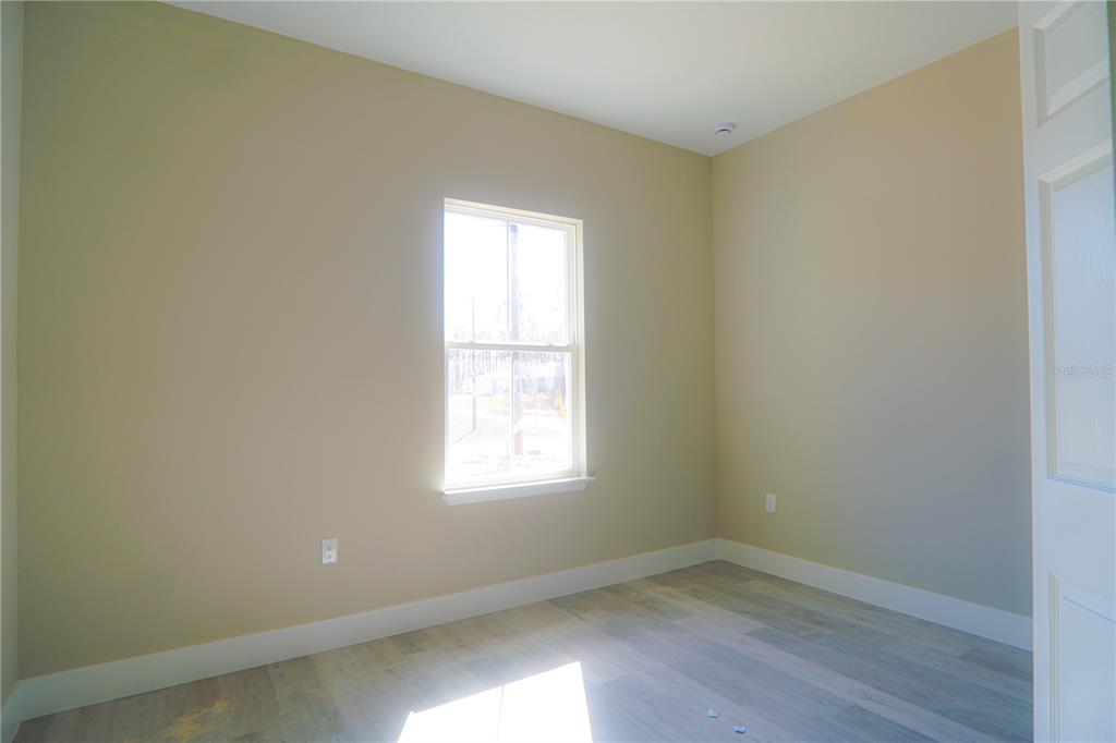 8413 Southwest 131st Lane Ocala, FL 34473 - Photo 19 of 28 an empty room with wooden floor and windows