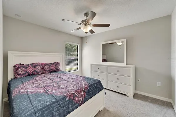 a bedroom with a large bed and a mirror on dresser