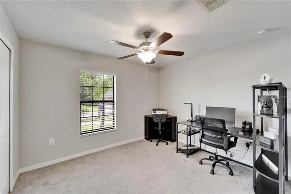 a view of a workspace with furniture and a window