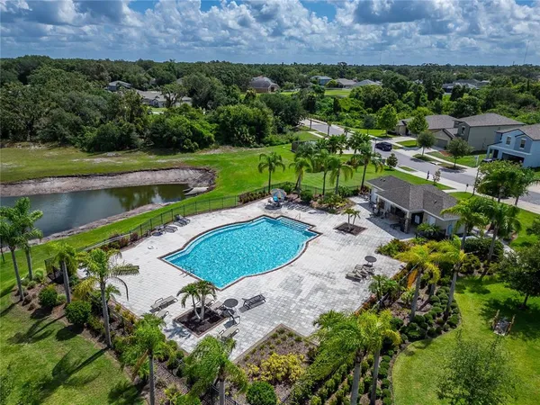 an aerial view of a house with a garden and lake view