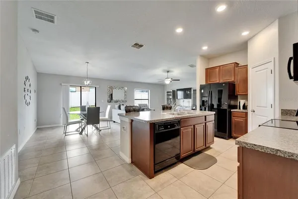 a kitchen with stainless steel appliances granite countertop a stove top oven a sink dishwasher and a refrigerator