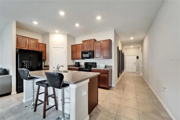 a kitchen with stainless steel appliances granite countertop a refrigerator and a stove top oven