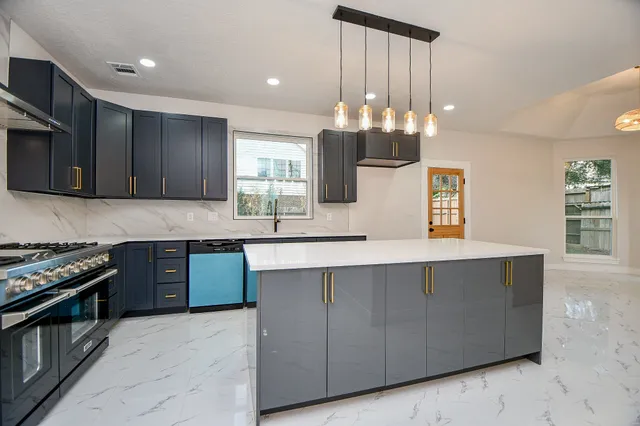 a kitchen with stainless steel appliances granite countertop wooden cabinets a stove top oven a sink and dishwasher