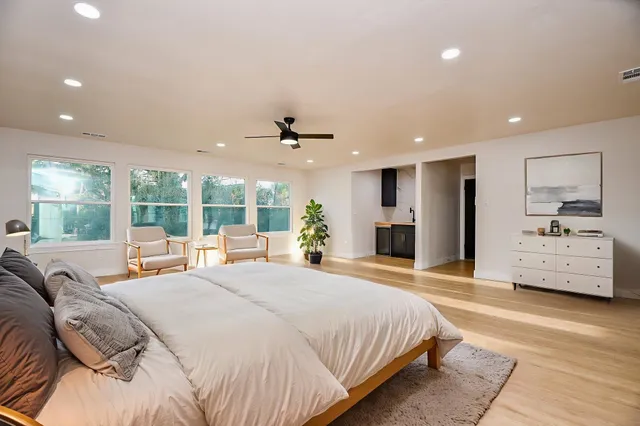 a spacious bedroom with a large bed and a large window