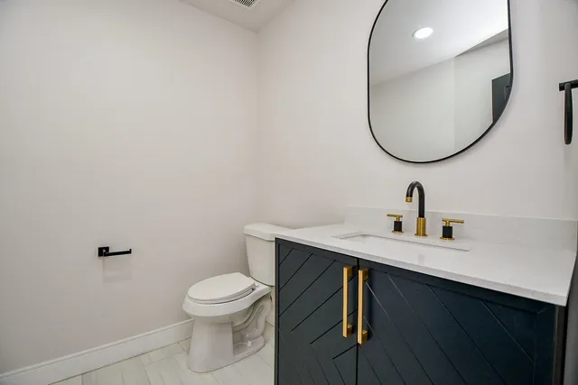 a bathroom with a toilet a sink and mirror