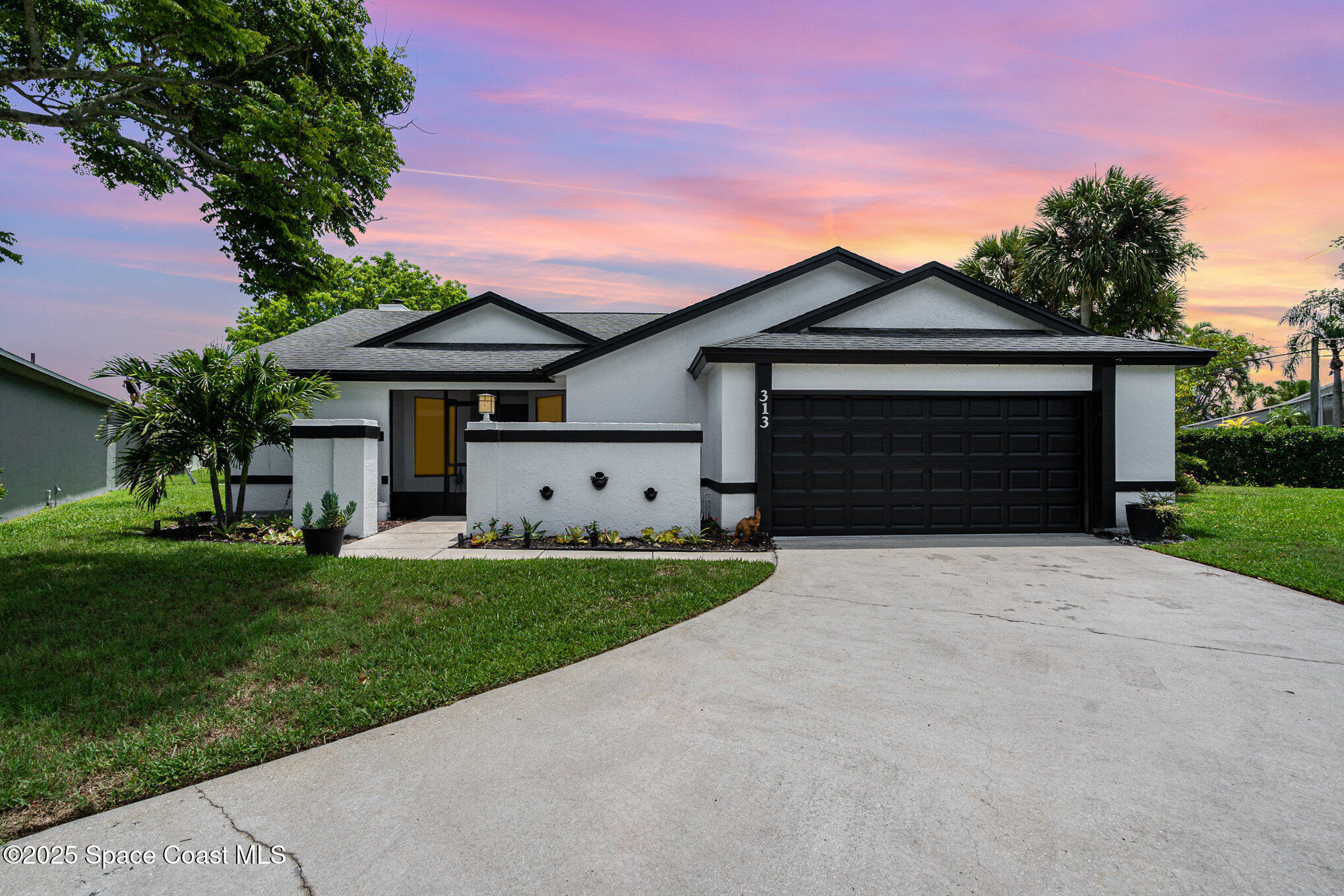 313 Pine Ridge Lane Melbourne, FL 32940 - Photo 1 of 28 a front view of a house with a yard and garage