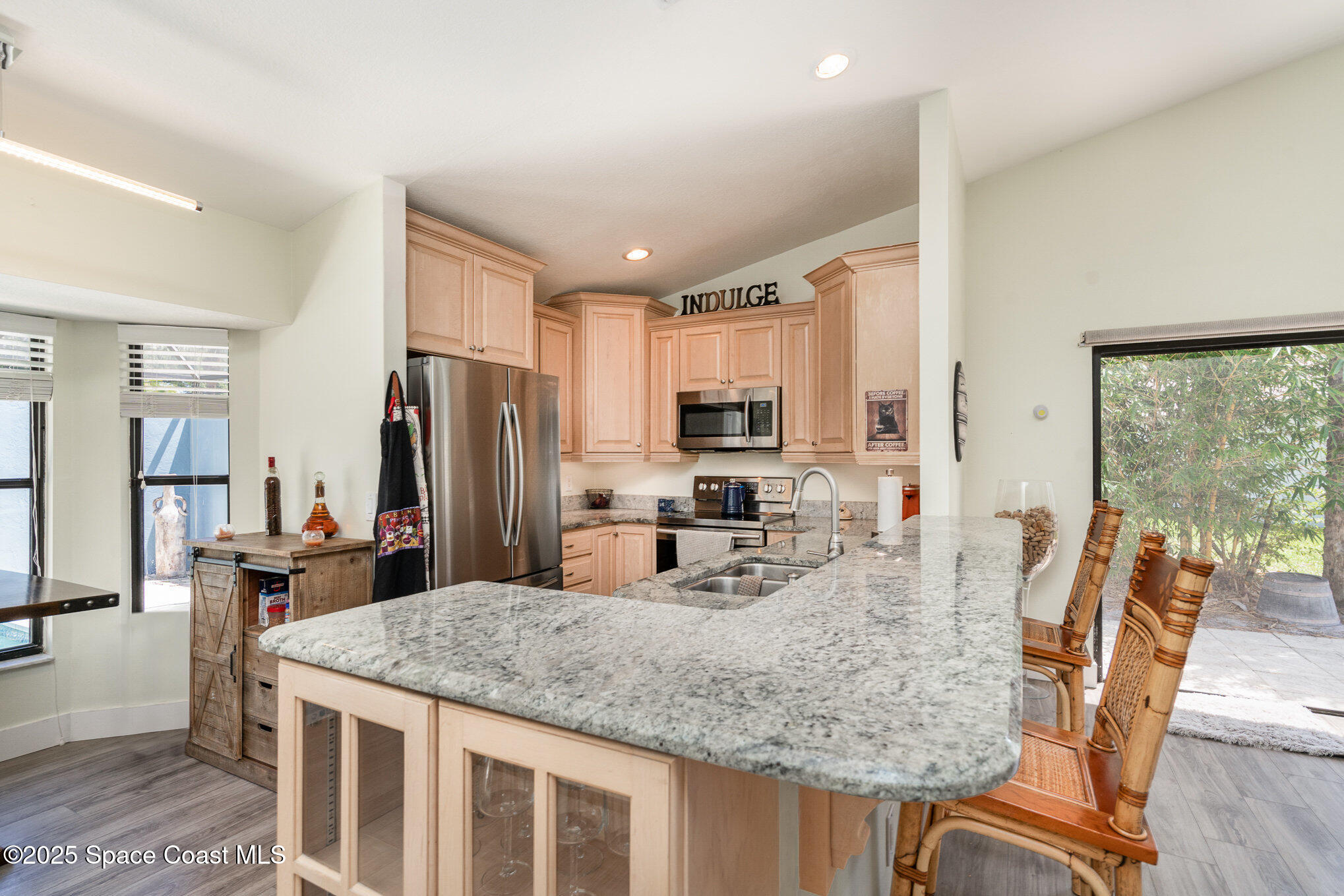 313 Pine Ridge Lane Melbourne, FL 32940 - Photo 11 of 28 a kitchen with stainless steel appliances granite countertop a kitchen island hardwood floor and a refrigerator