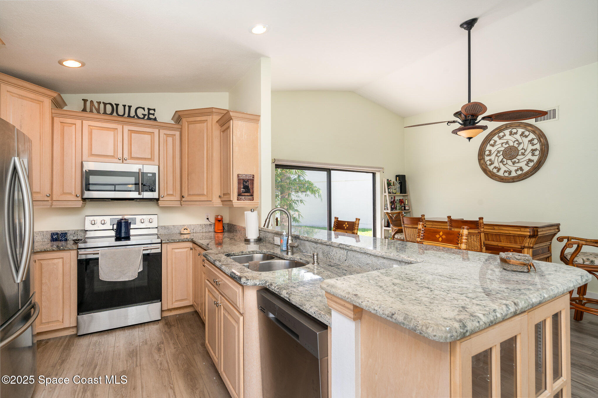 313 Pine Ridge Lane Melbourne, FL 32940 - Photo 12 of 28 a kitchen with stainless steel appliances granite countertop a sink a stove and a wooden floors