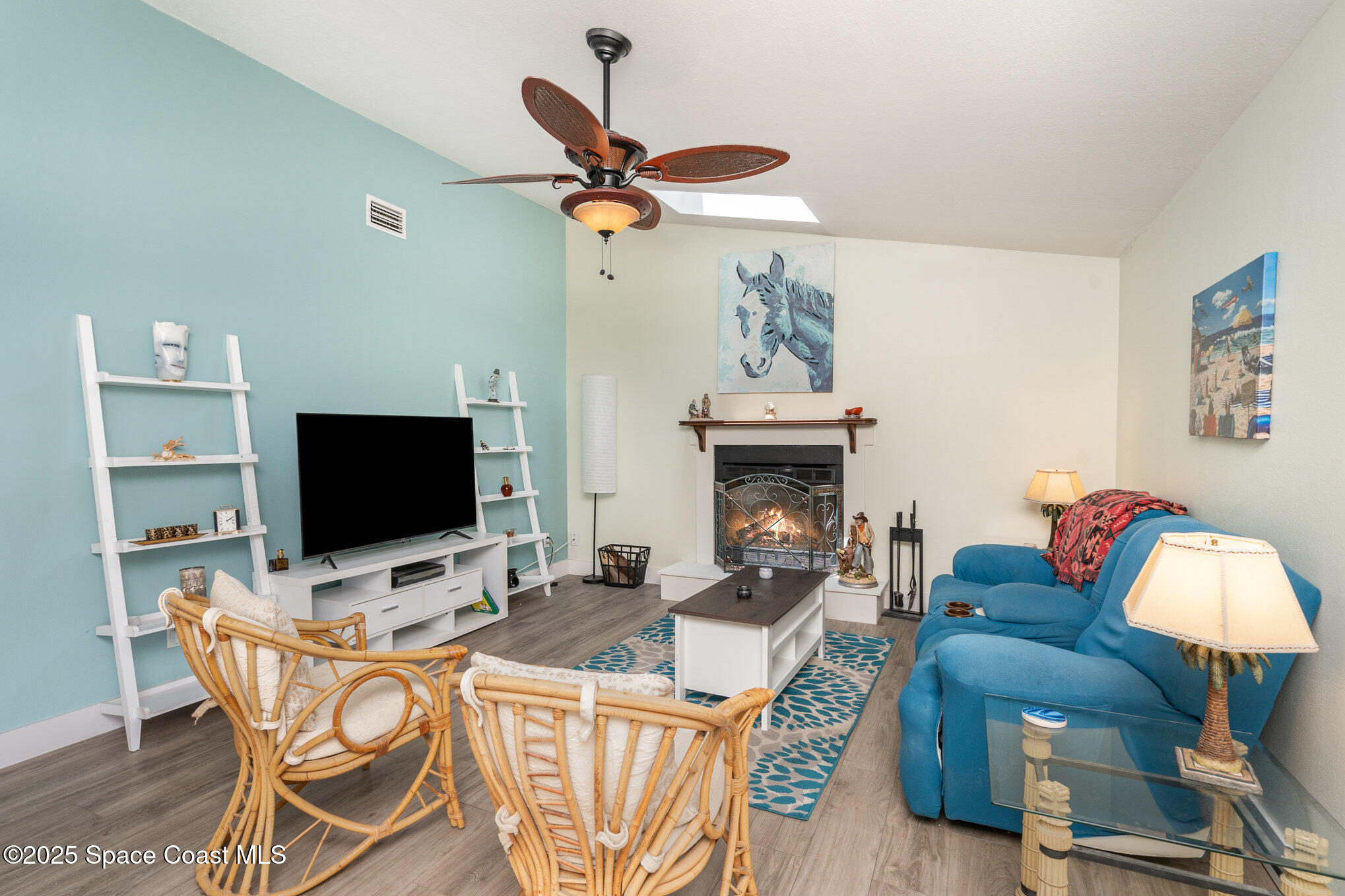 313 Pine Ridge Lane Melbourne, FL 32940 - Photo 5 of 28 a living room with furniture a flat screen tv and a chandelier