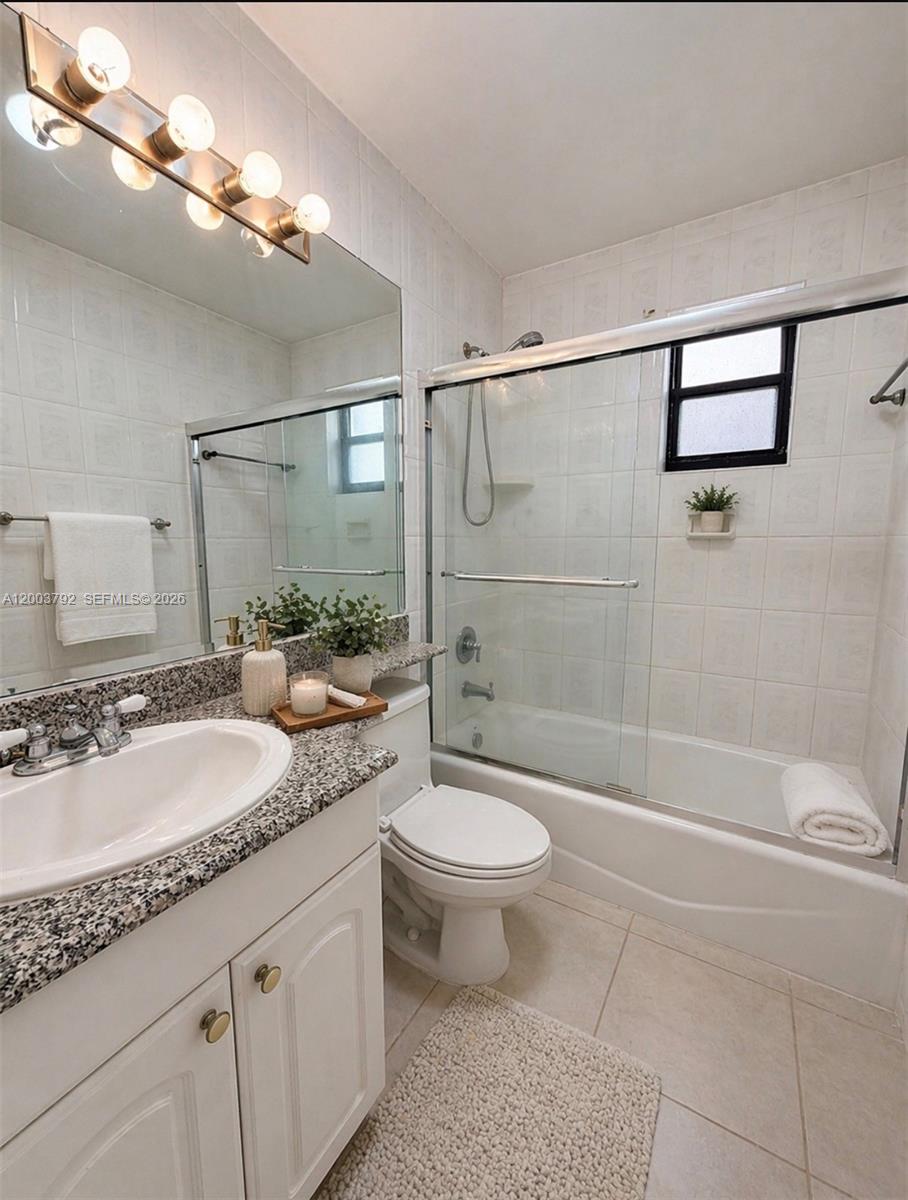 13525 Southwest 115th Place Miami, FL 33176 - Photo 6 of 10 a bathroom with a granite countertop sink a toilet a mirror and shower