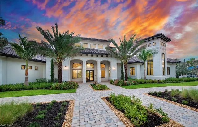 a front view of a house with a garden and trees
